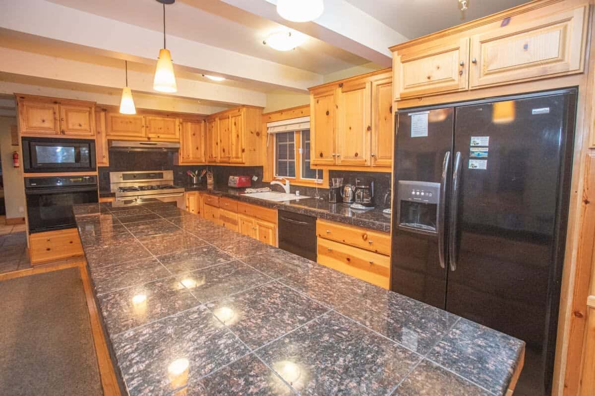 The large and well-equipped kitchen is complete with stainless steel appliances, granite countertops, and a large dining table providing all you need to prepare a delicious meal.