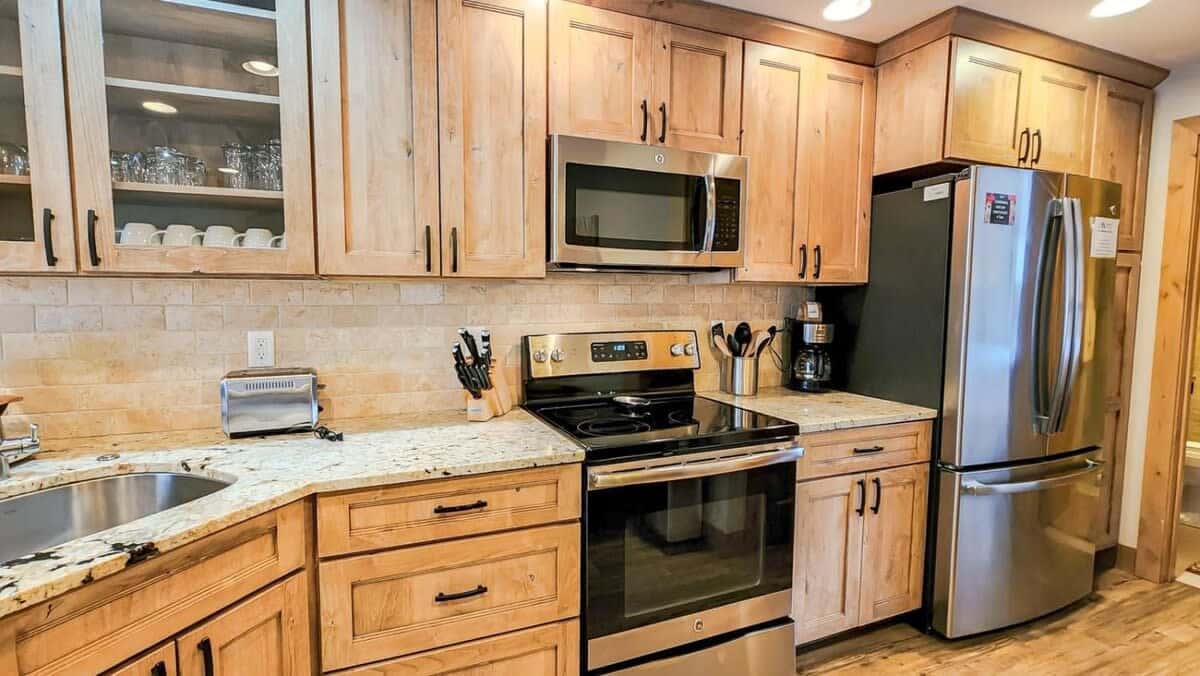 The fabulous, remodeled kitchen features stainless steel appliances, a tile backsplash and modern finishes. It also has a bar that makes for easy serving and dining for two.