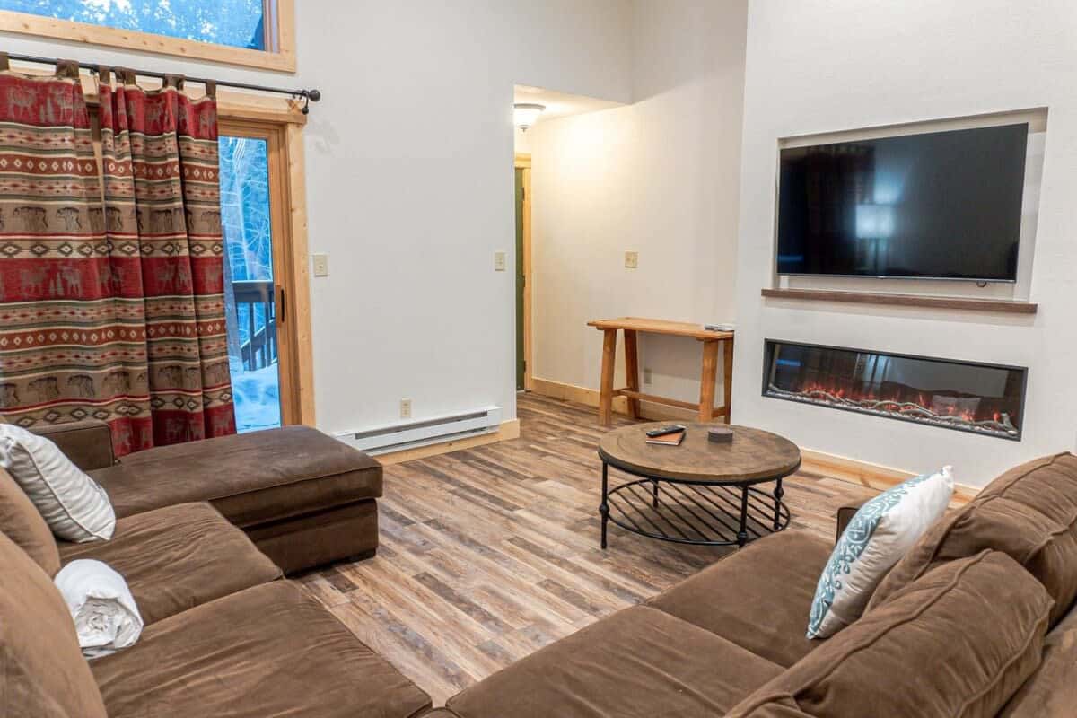 Relax away in the inviting living room that features a sectional sofa, a flat-screen TV, a lovely electric fireplace, and access to the private patio.
