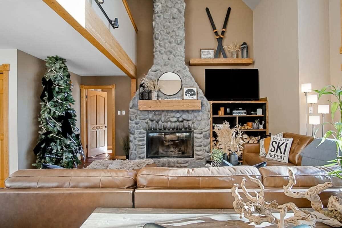 Relax in the luxurious leather sofa with a cozy wood-burning fireplace, a large flat-screen TV, and stunning forest views through the expansive windows