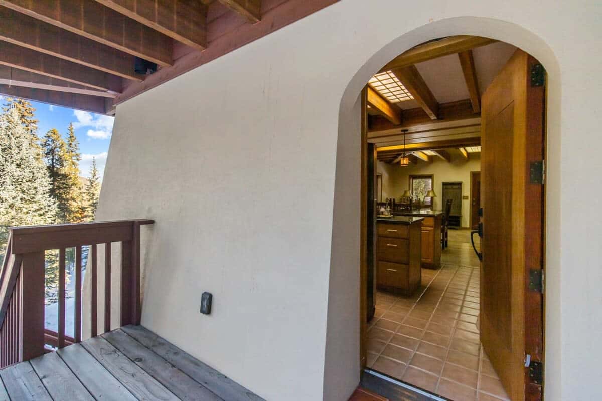 Through the arched doorway, find the roomy kitchen featuring an island, bar space with seating and stainless steel appliances.