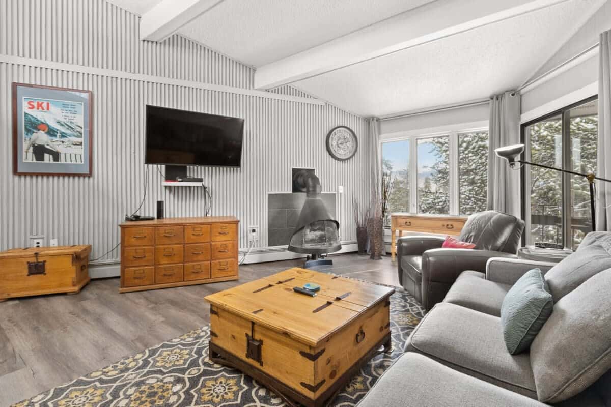 The stunning living area is bathed in light and features beamed ceilings, a unique gas fireplace, a large dresser, 50-inch, flat-screen TV, leather armchair, coffee table and cozy couch that doubles as a queen-size pullout.