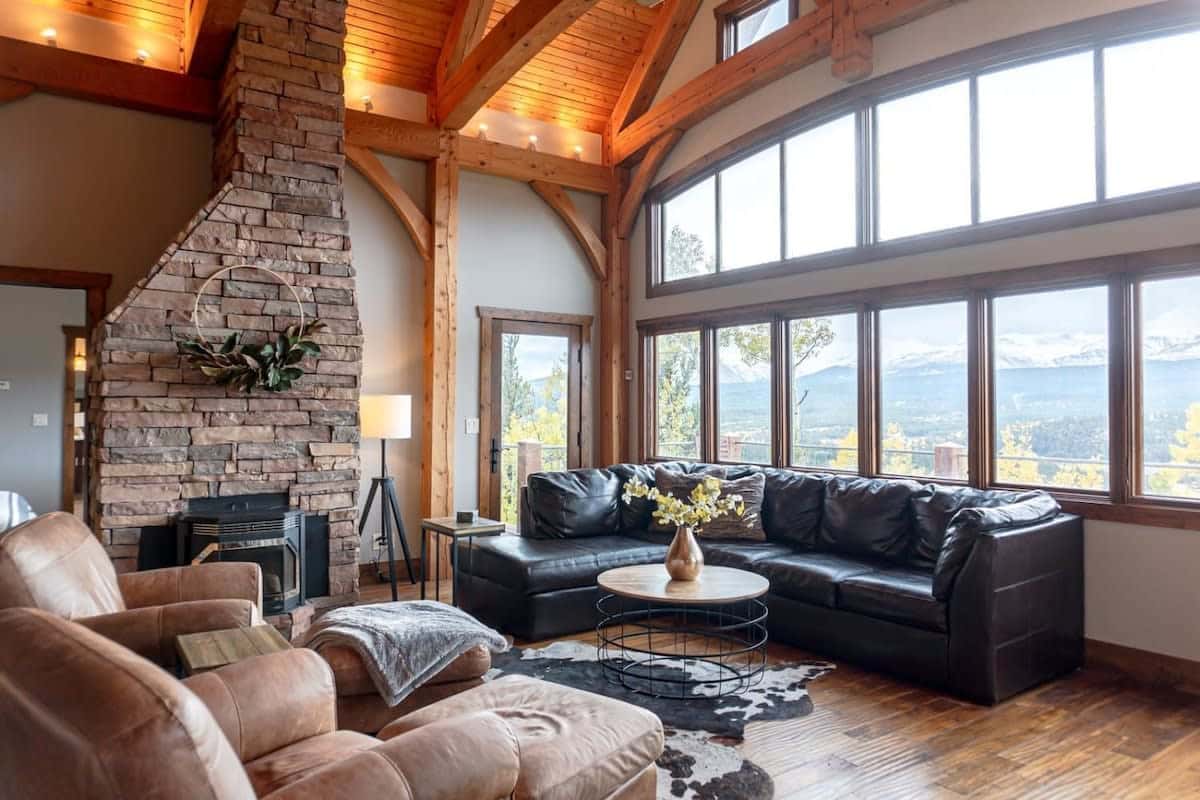 The great room is made up of a leather sectional and two chairs complete with the stunning views out the soaring windows in this space.