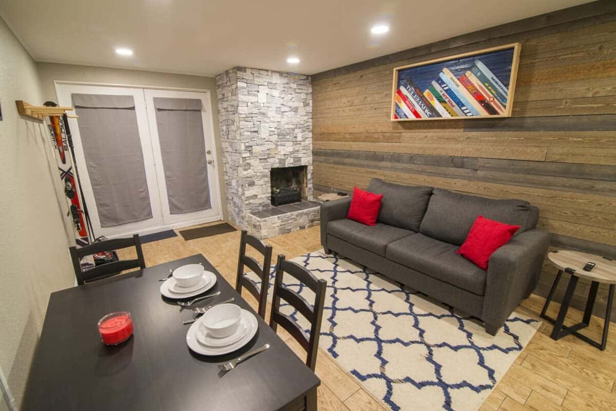 The combined living and dining room is a dynamic space for relaxing, eating, or having a game night with a beautiful stone electric fireplace to warm up by.