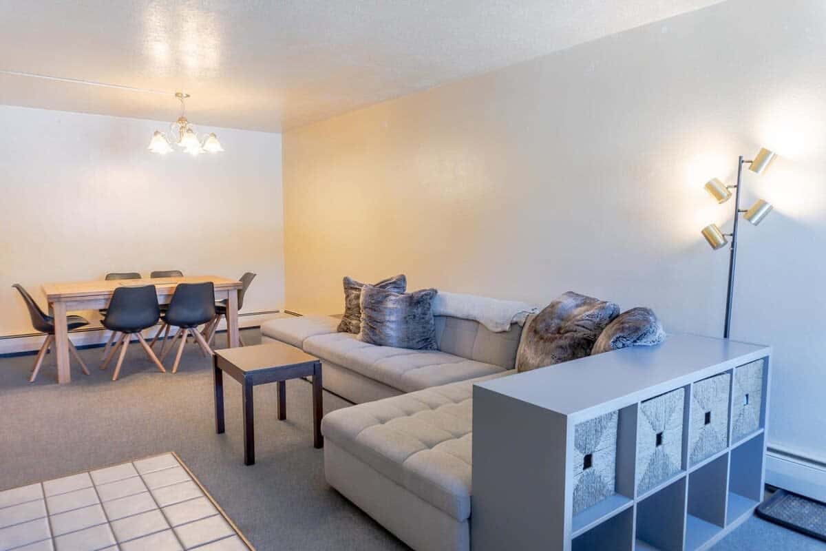 The open living room and dining space in the apartment create a dynamic space for relaxing, eating, or having a game night.