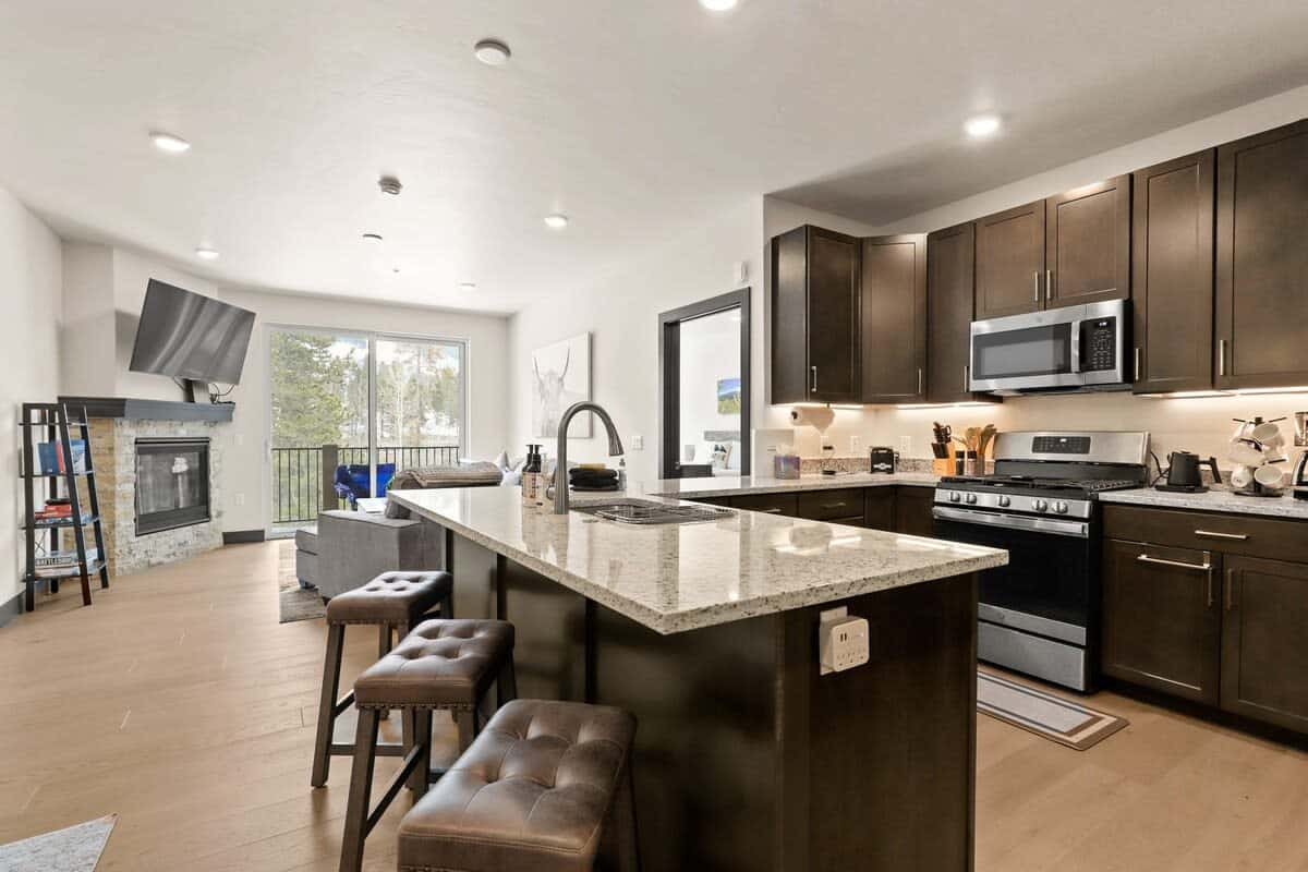 The stylish condo is a light-filled space with beautiful wood floors, an open layout, and views out toward the surrounding trees.