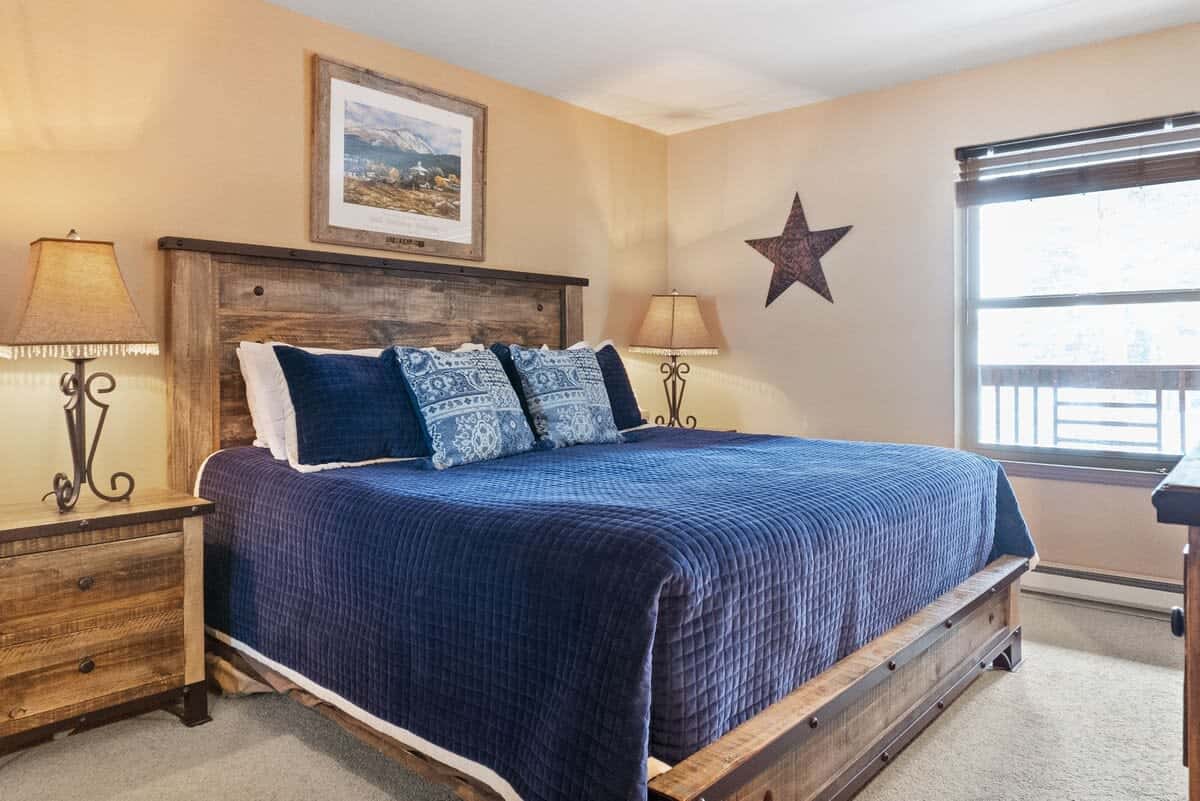 The cozy master bedroom boasts a king-size bed in a lovely bed frame, a 55” TV, and an attached full bathroom.