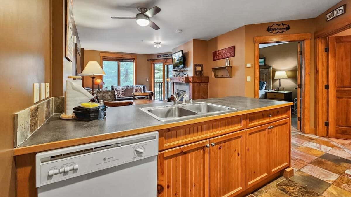 From the kitchen, you have a view into the living room and out the large windows overlooking the surrounding trees.