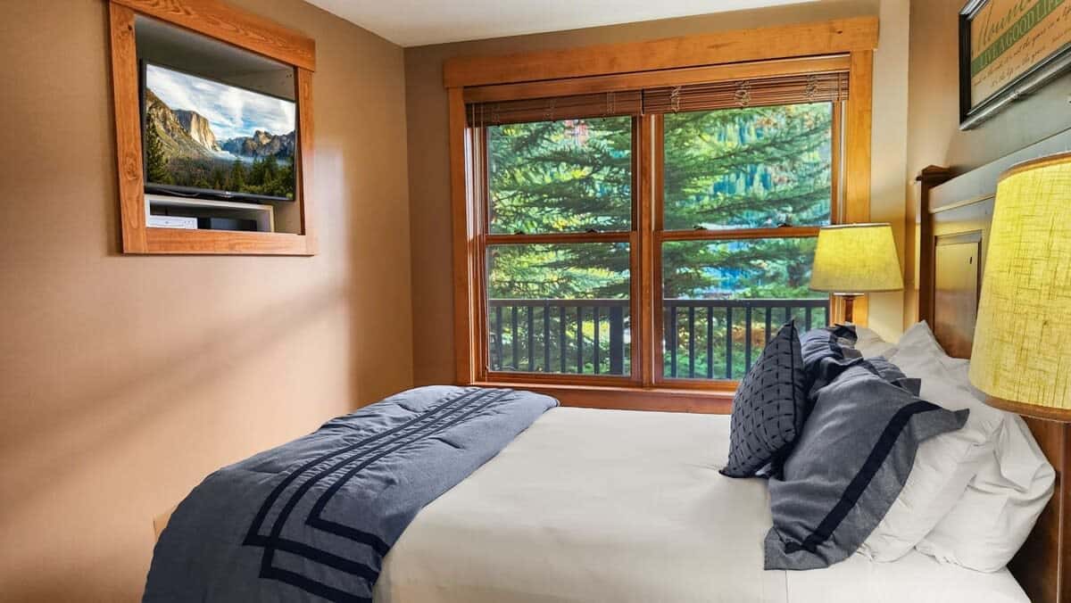 The inviting bedroom is filled with natural light from the large window that looks out towards the mountains so you can wake up and start your day with mountain views!