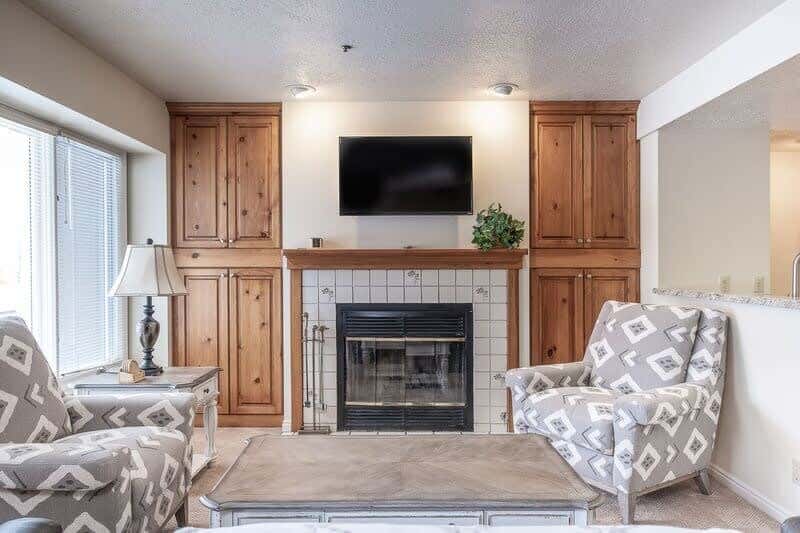 Cozy up with your loved ones in the living room with a comfortable sofa and armchair seating, an indoor wood fireplace, and a flat-screen TV