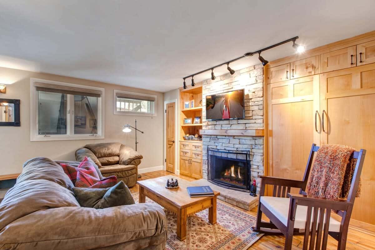 Relax in the family room with a plush sofa, armchair seating, a warm indoor fireplace, and a flat-screen TV