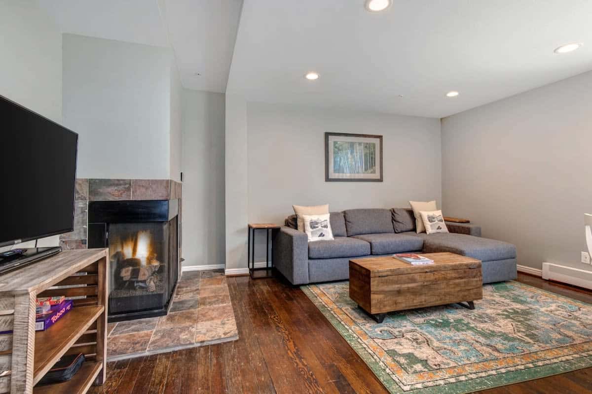 The inviting, open-concept living area has it all - from a cozy fireplace to a flat-screen TV with a Roku and DVD player to a comfortable sectional sofa that doubles as a queen-size, pull-out bed.