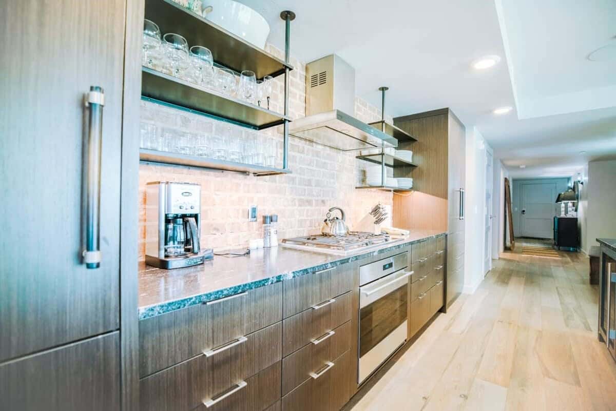 From the stone countertops to the top-of-the-line, stainless steel appliances and large island with pendant lighting, this kitchen has style in spades. It is also full stocked with everything from a tea kettle and toaster to elegant stemware.