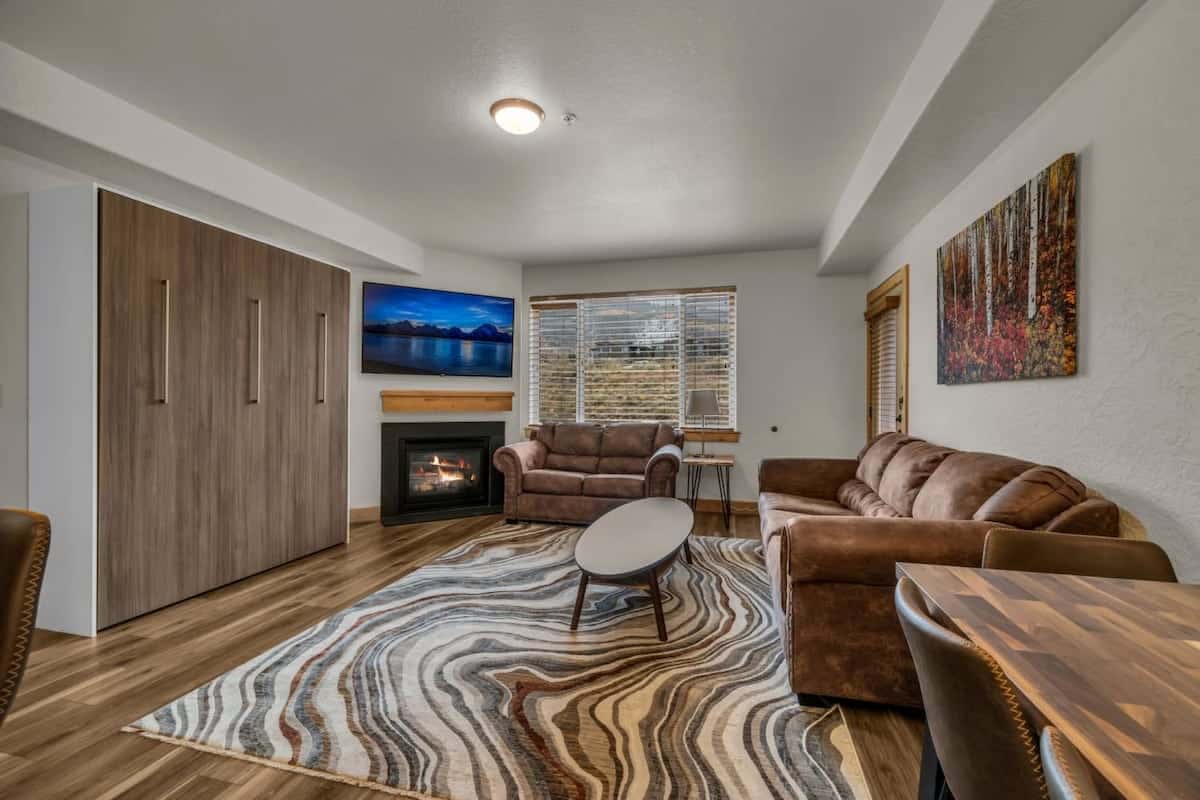 The view over the stylish open kitchen/dining/living room, this space is filled with natural light and comfortable seating options perfect for your group to relax together.