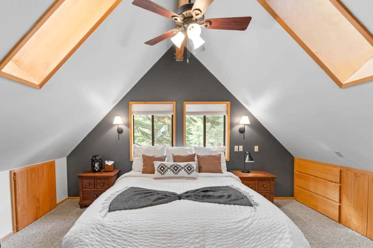 Relax and recharge in the master suite, a beautiful room with a king-size bed, cathedral ceilings, exposed wood beams, and skylights.