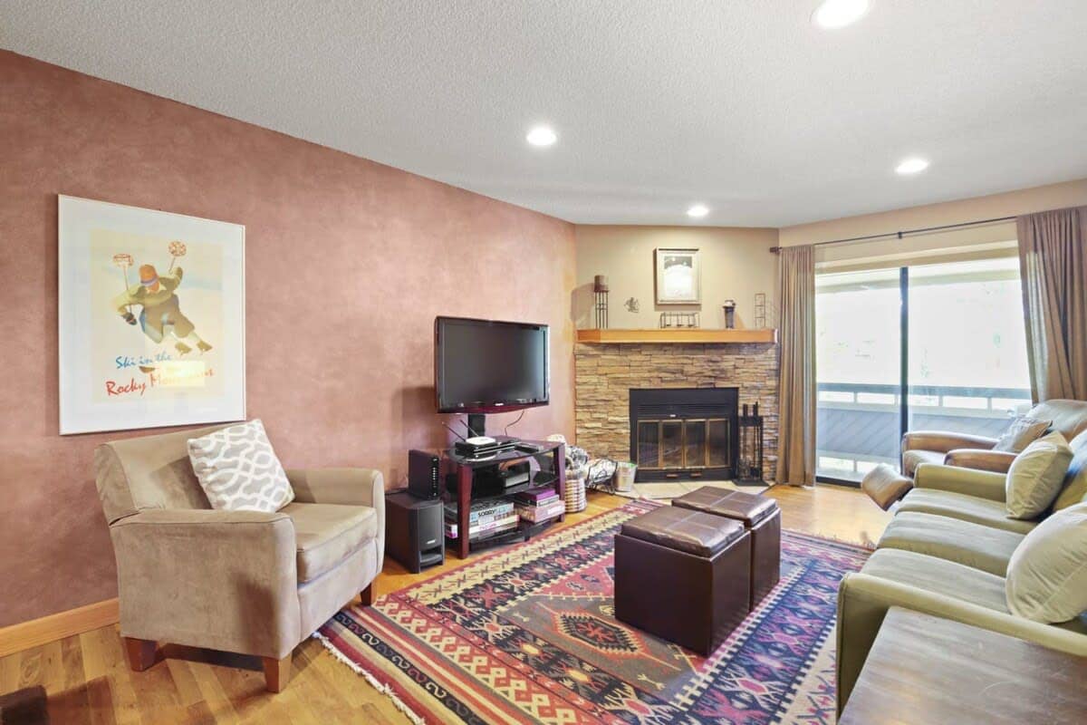 The inviting living room places a focus on comfort with a plush couch, cozy recliner, reading chair and two ottomans for you to kick back and relax. A beautiful stone fireplace, media console & flat-screen TV round out the space.
