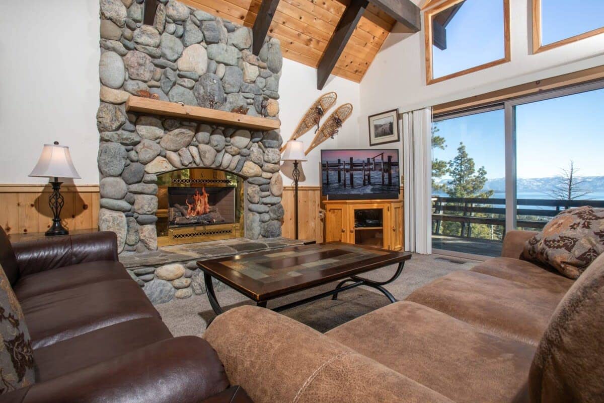 The living room includes two couches to relax on as you warm up by the large gas fireplace situated in an impressive stone hearth, a 47” smart TV, and access to the private deck with lake views.