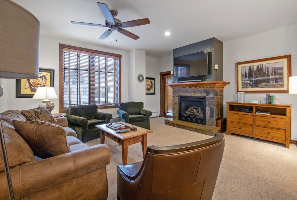 Living room with gas fireplace, mounted TV, and access to private balcony