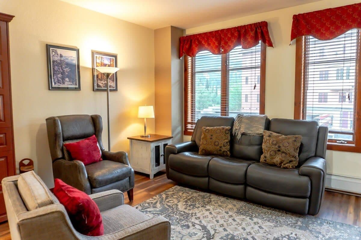 The cozy living room where you will find a pull out sofa, two armchairs, end tables, lamps, a flat-screen TV and a gas fireplace as well as access to a private balcony. A convenient Murphy bed also pulls out into a queen-size bed.