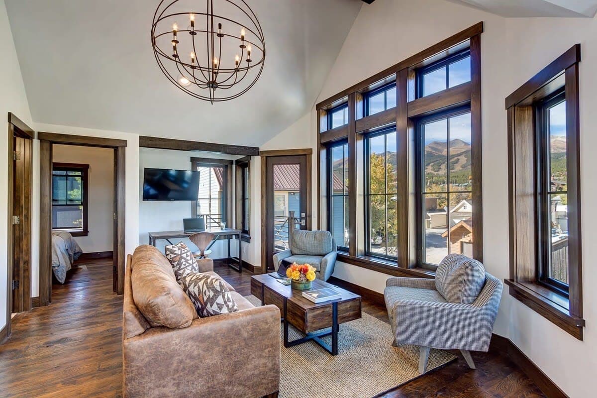 Living room with mounted TV, desk, and access to private balcony