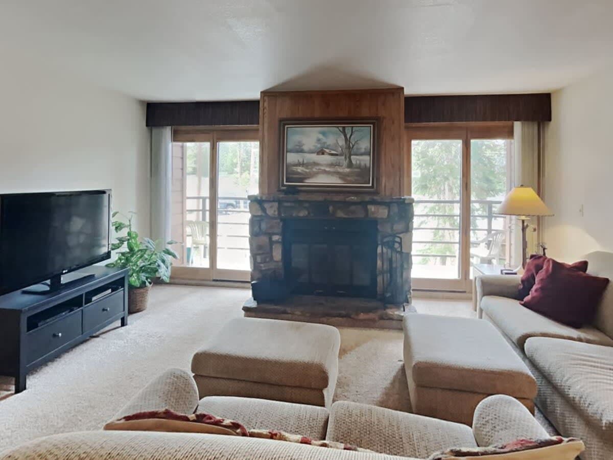 This cozy home offers up an intimate layout and an open-concept floor plan focused on a beautiful, wood-burning fireplace featuring striking stone work and flanked by two large windows that bathe the space in natural light.