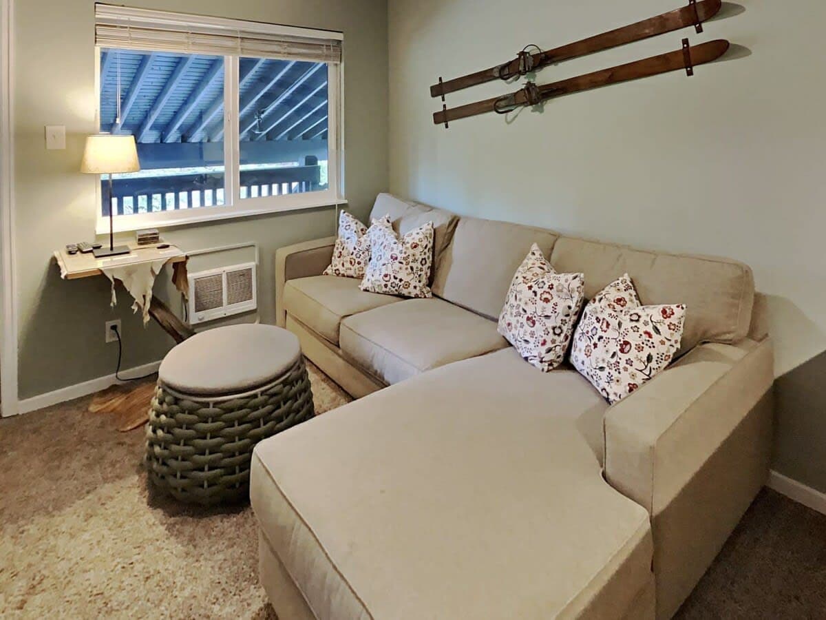 Make yourself at home in this cozy living area with its inviting sectional sofa, coffee table/ottoman, end table, lamp, dresser and flat-screen TV.