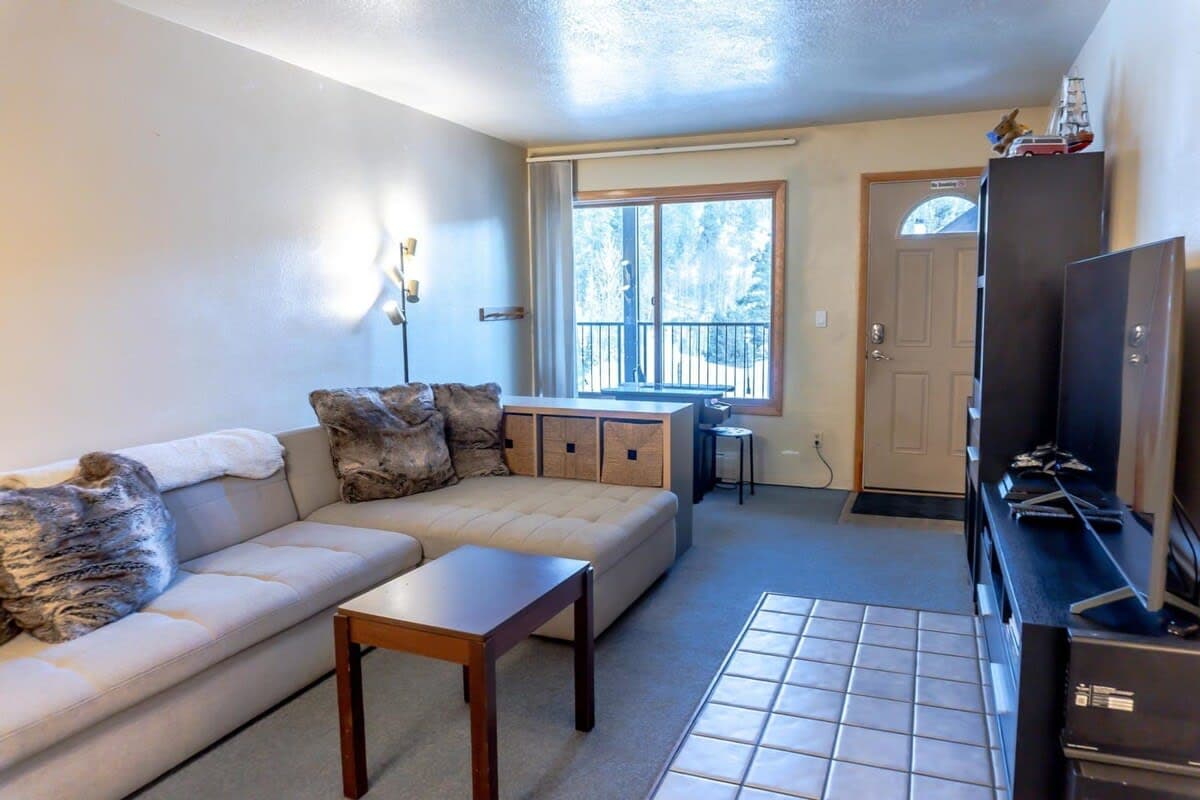 The open living room is a dynamic space perfect for relaxing with your group with a large sectional sofa, an entertainment center complete with a 60” TV, puzzles, and games, and an arcade table with games like Ms. Pac-Man and Donkey Kong.