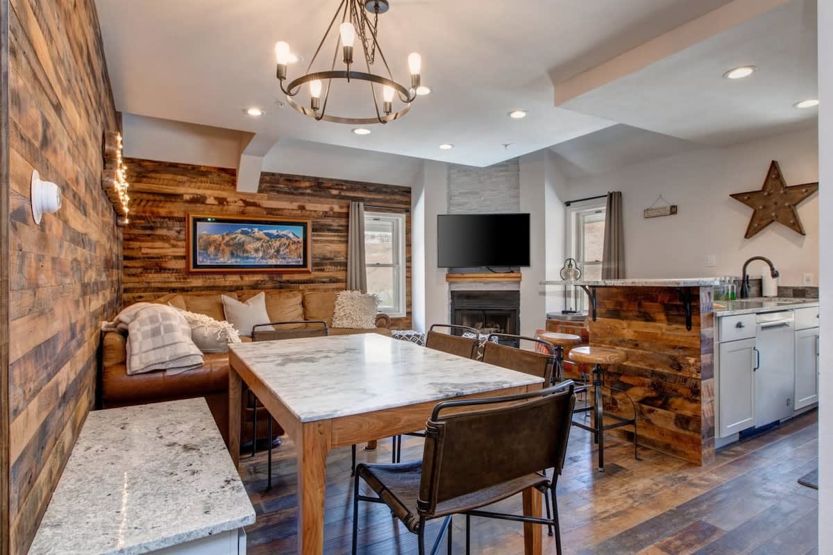 The open-concept living/dining/kitchen area in this one-of-a-kind condo with stylish, inviting decor gives the vibe of a boutique hotel while offering all of the comforts of home.