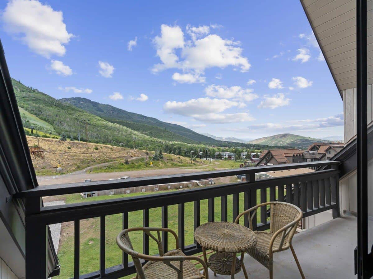The stellar view of the mountains, resort base and chair lifts as seen from the private balcony, with its patio table and seats for two.