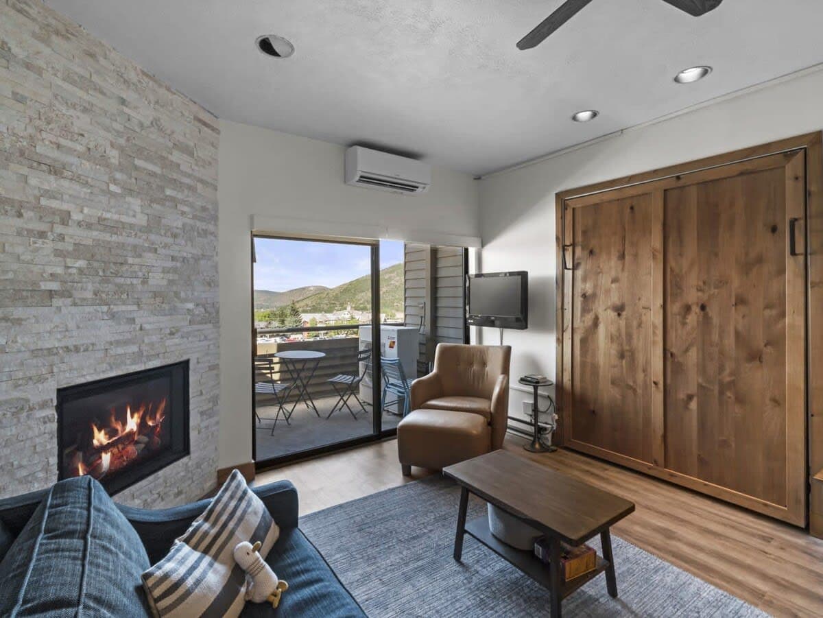 The beautiful living area features a stone fireplace, leather armchair and ottoman, loveseat/twin sleeper sofa, coffee table, flat-screen TV and a queen-size Murphy bed. This space also enjoys access to the patio with views of Old Town.
