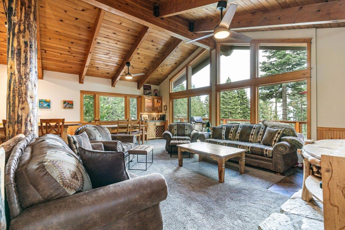 Kick back and relax in the bright & open main living area, boasting plush furnishings and windows all around providing views over the surrounding nature from all angles.